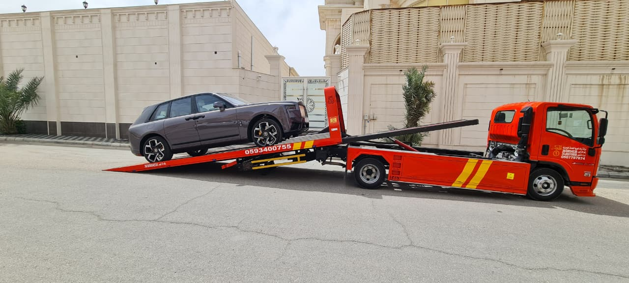 سطحة احترافية تنقل سيارة فاخرة أمام فيلا سكنية